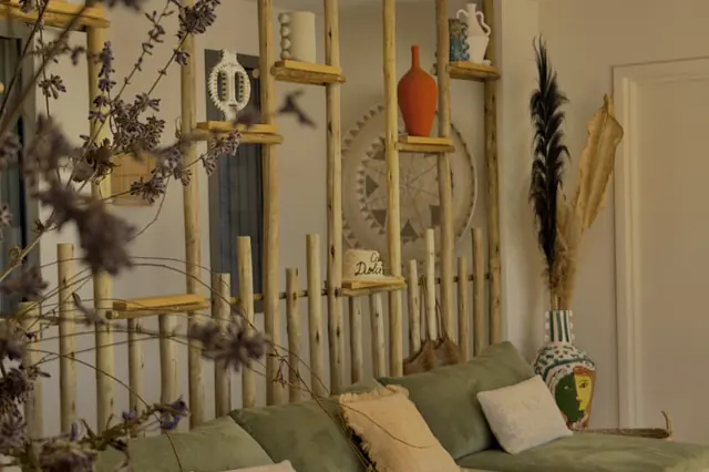 Living room with sage-green sofas and ceramic shelves